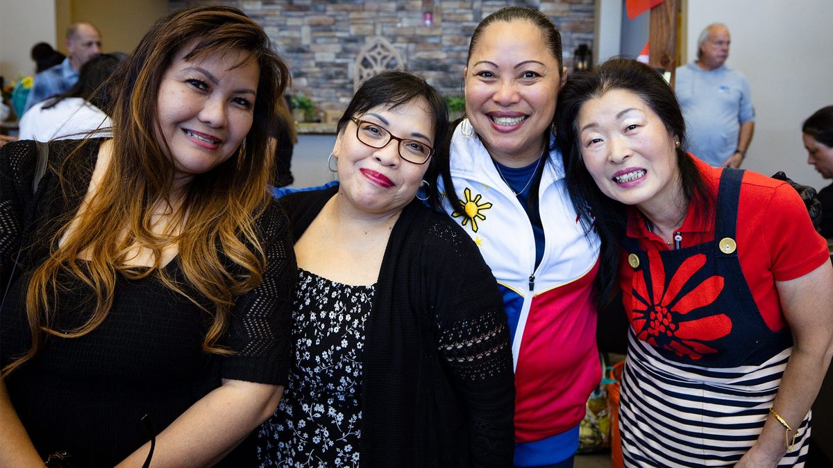 Four women smile together at a Flourish gathering