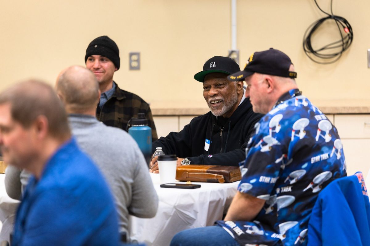 Men talk and laugh around a table at a Bible study night